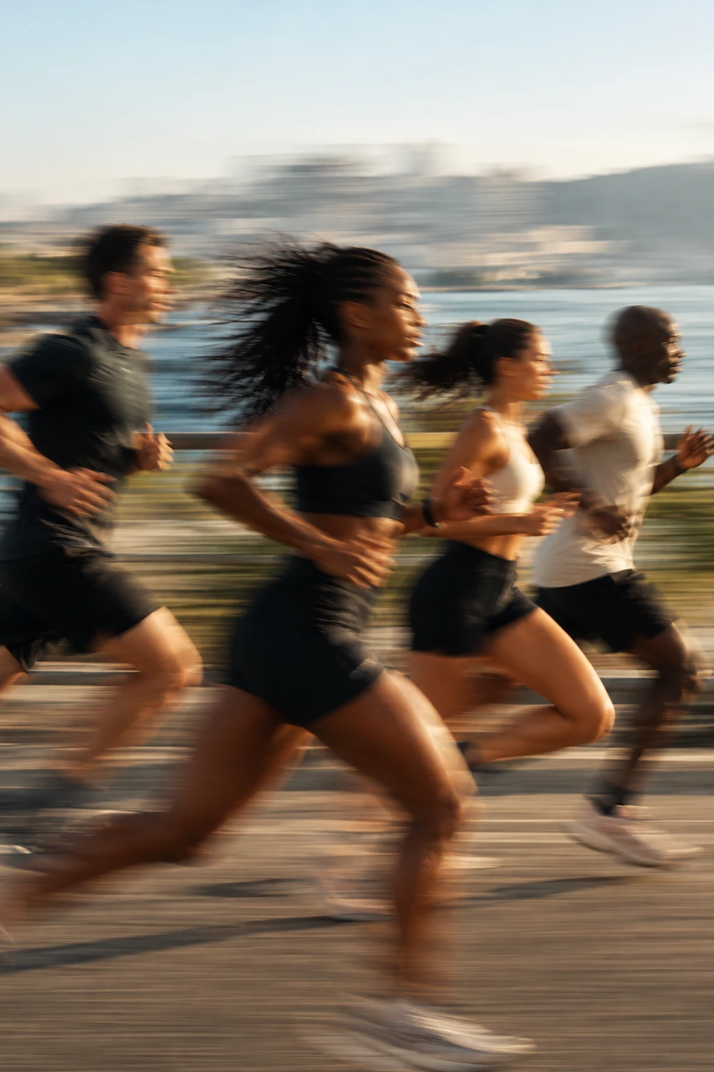 People running together by the sea in the late afternoon